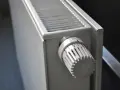 Biały grzejnik z termostatem ustawionym na 3. To element ogrzewania elektrycznego mieszkania, zapewniający komfort cieplny.
