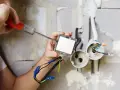 Elektryk montuje włącznik światła. Zastanawiasz się, ile kosztuje prąd budowlany?