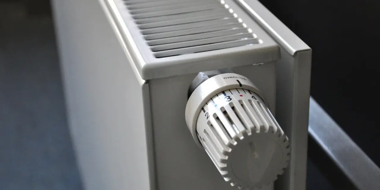 Biały grzejnik z termostatem ustawionym na 3. To element ogrzewania elektrycznego mieszkania, zapewniający komfort cieplny.