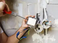 Elektryk montuje włącznik światła. Zastanawiasz się, ile kosztuje prąd budowlany?