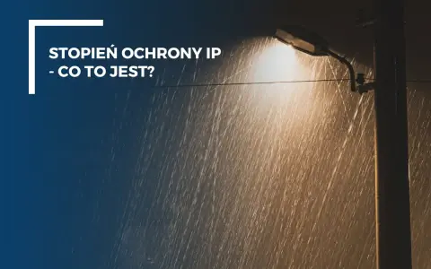 Latarnia uliczna świeci w deszczu. Tekst informuje, co oznacza stopień ochrony IP55, czyli odporność na kurz i strumienie wody.