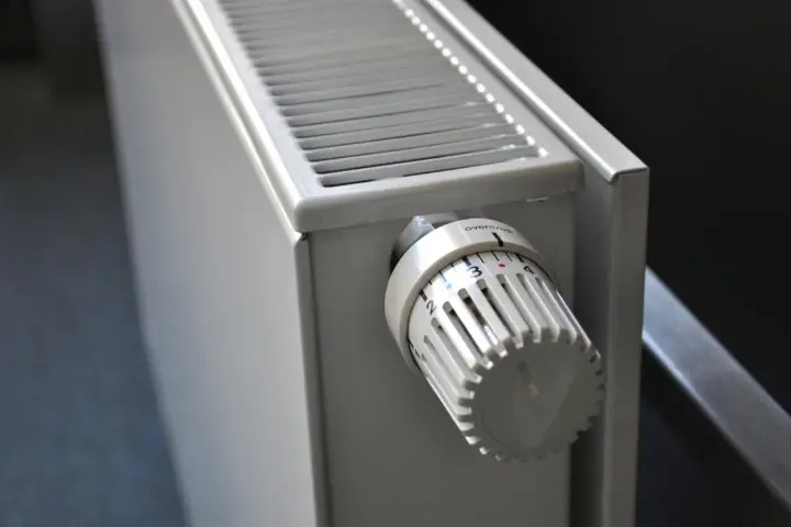 Biały grzejnik z termostatem ustawionym na 3. To element ogrzewania elektrycznego mieszkania, zapewniający komfort cieplny.