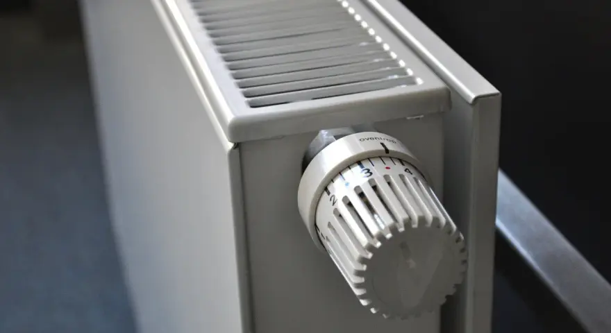 Biały grzejnik z termostatem ustawionym na 3. To element ogrzewania elektrycznego mieszkania, zapewniający komfort cieplny.