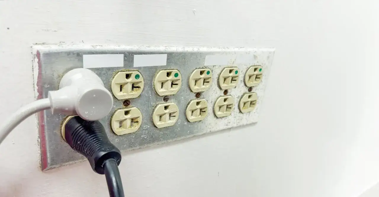 Kilka gniazdek elektrycznych, jeden z białym adapterem, drugi z czarnym kablem. Kontakt gniazdko gotowy do użycia.